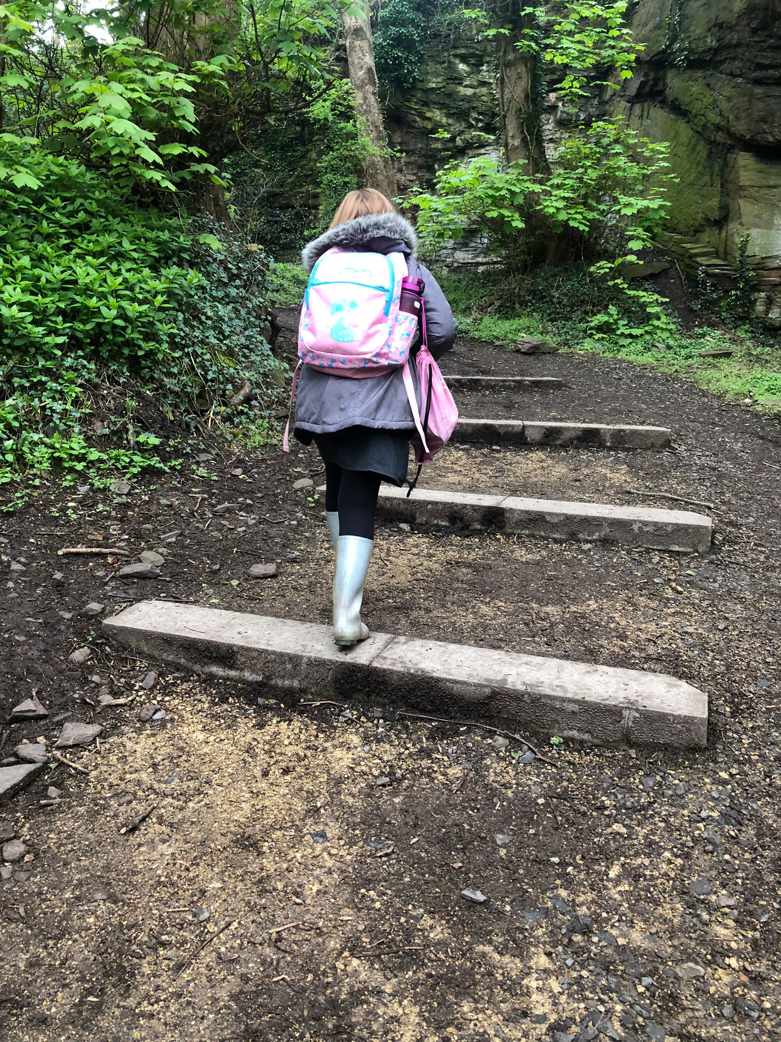 小學生穿着水靴、背着書包，行泥濘路回校。見過他們在返到學校前，就在路口換上皮鞋才去上學。